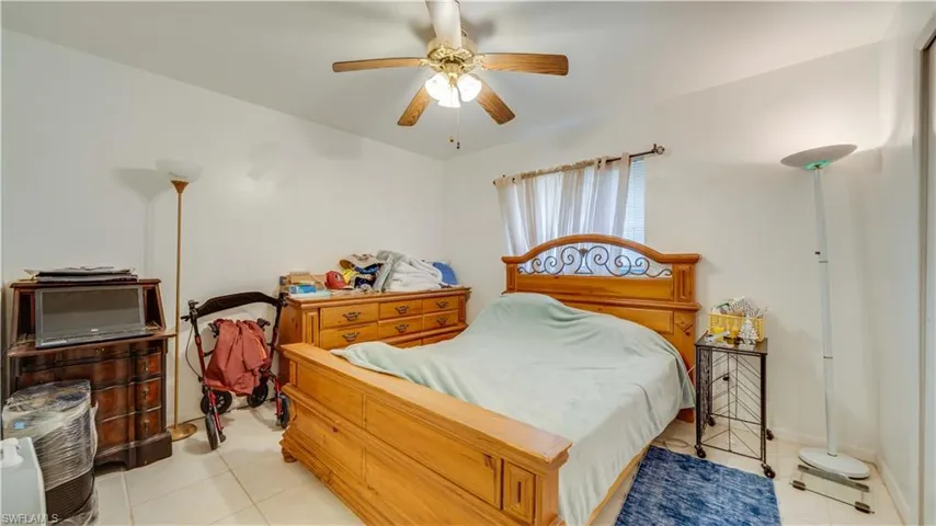 Bedroom with light tile patterned floors and a ceiling fan