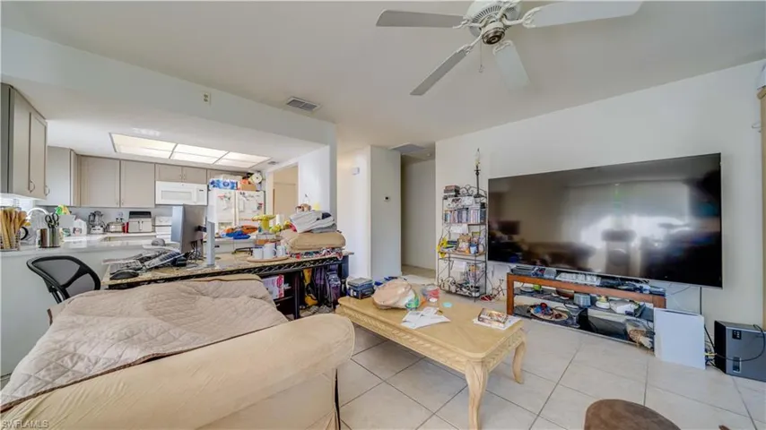 Living area with light tile patterned flooring and a ceiling fan
