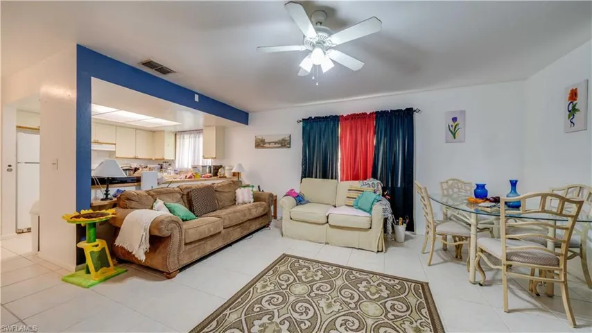 Living area featuring ceiling fan and light tile patterned flooring