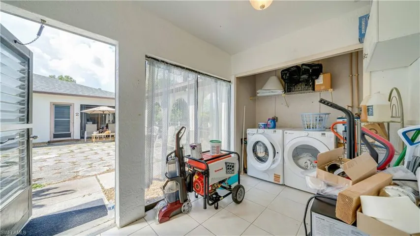 Laundry room featuring tile patterned floors and washer and clothes dryer