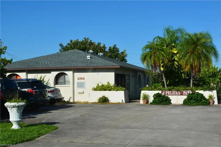 View of home's exterior with stucco siding, roof with shingles, and driveway