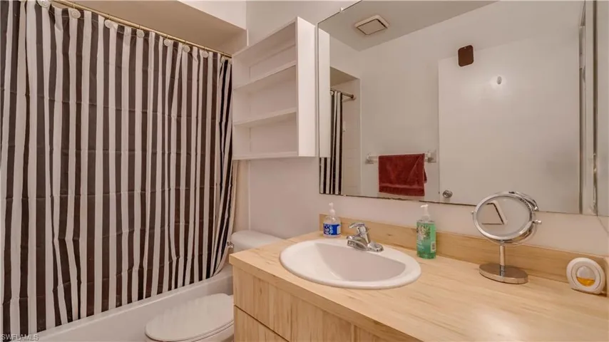 Full bathroom with shower / bath combination with curtain and vanity