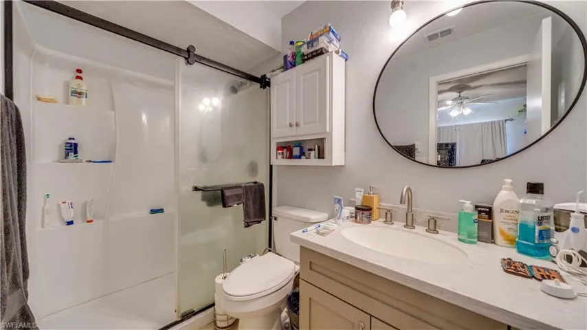 Full bath with a stall shower, vanity, and a ceiling fan