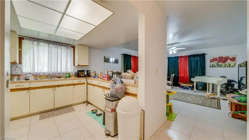 Kitchen featuring light tile patterned floors, light countertops, and a ceiling fan