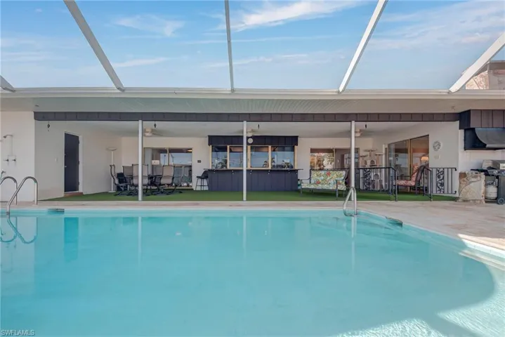 Indoor pool featuring glass enclosure and a patio