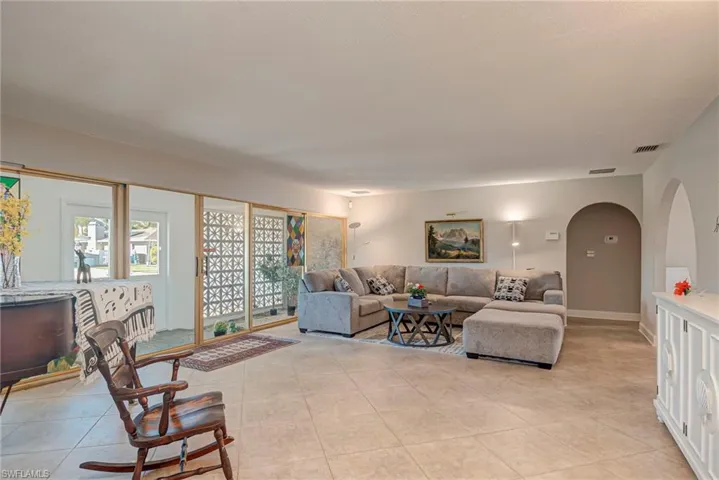Living room with arched walkways and light tile patterned floors