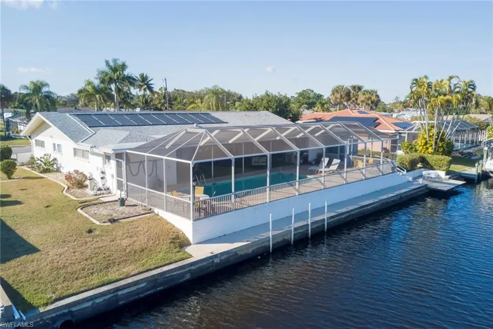 Dock area featuring an outdoor pool, a lanai, a lawn, a water view, and a sunroom