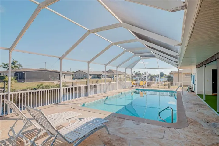 View of pool featuring a lanai, a patio, a sunroom, and a lawn