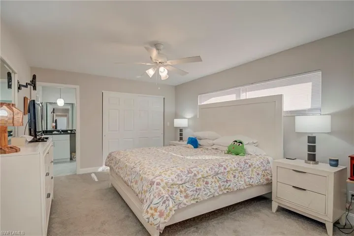 Bedroom with light carpet, a closet, and ceiling fan