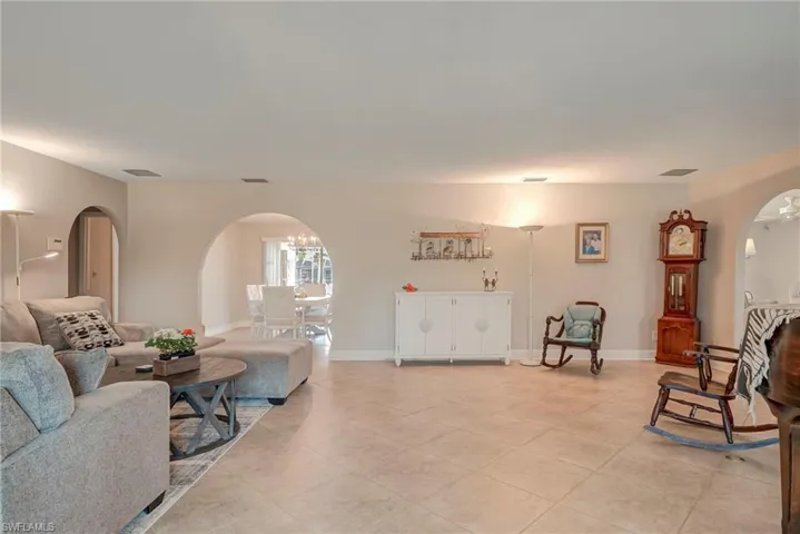 Living area featuring arched walkways and light tile patterned floors