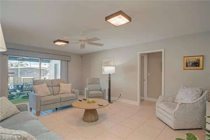 Living room with light tile patterned floors and ceiling fan