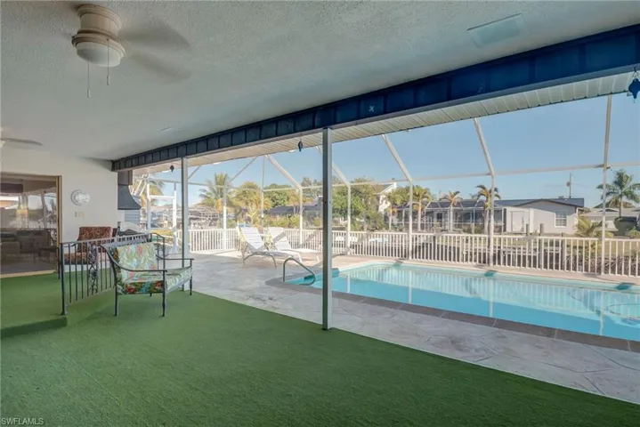 View of pool featuring a lanai, a patio, a sunroom, and a lawn