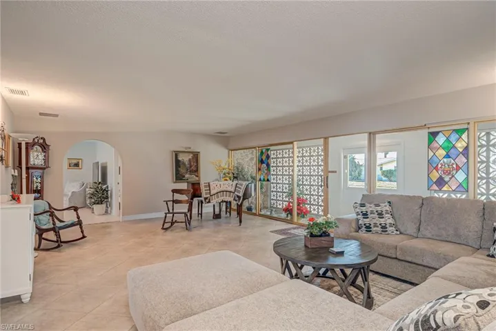Living room featuring arched walkways and light tile patterned floors