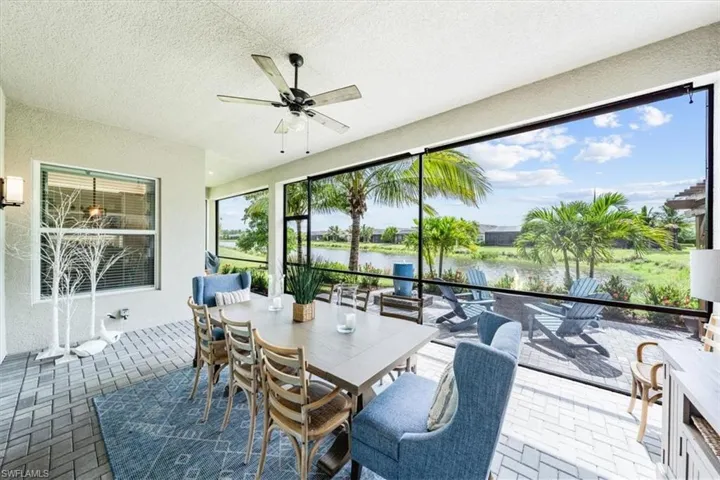 Sunroom featuring ceiling fan, a water view, and a healthy amount of sunlight