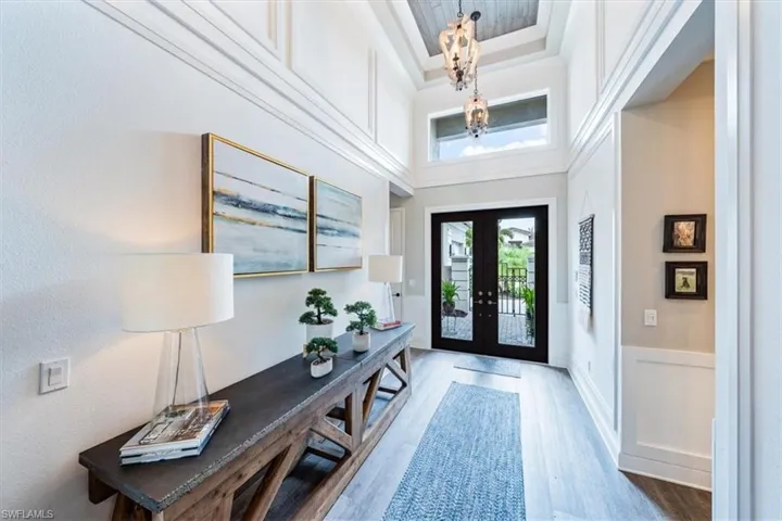 Foyer with a towering ceiling, french doors, and hardwood / wood-style flooring