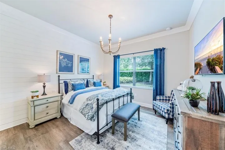 Bedroom with wood-type flooring and a notable chandelier