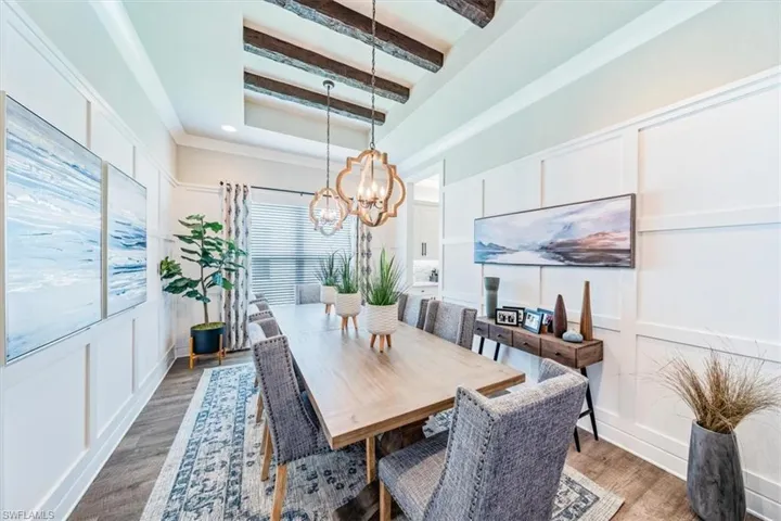 Dining room featuring a chandelier, beamed ceiling, and dark hardwood / wood-style floors