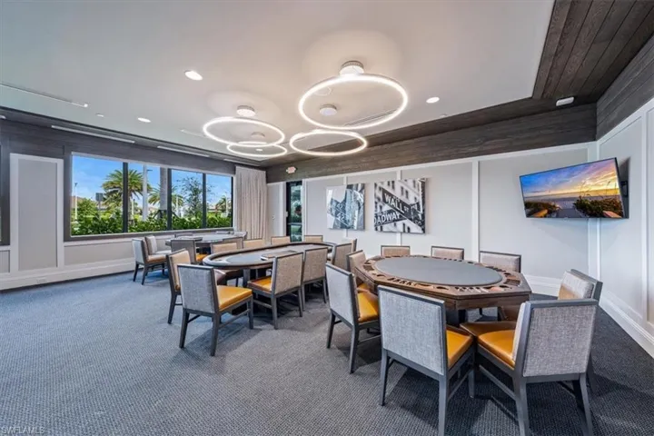 Dining area featuring an inviting chandelier, carpet, and a raised ceiling