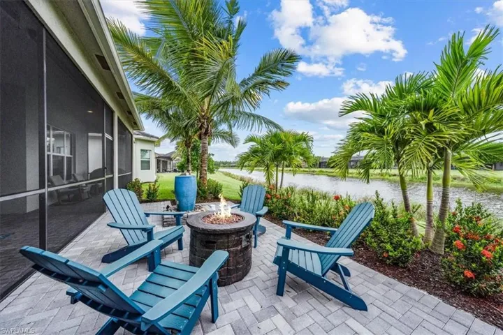 View of patio / terrace with glass enclosure, a water view, and an outdoor fire pit