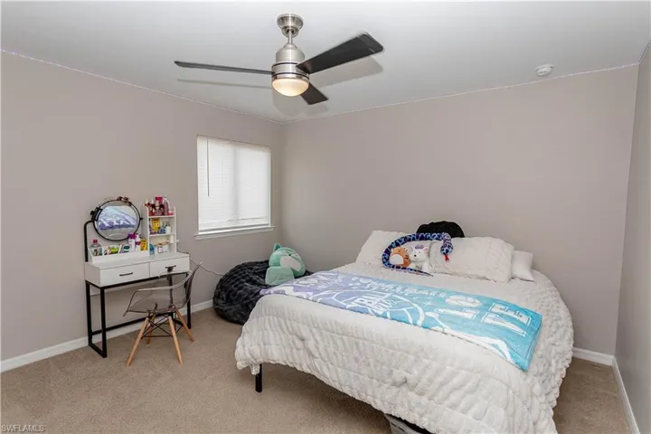 Bedroom featuring light carpet and a ceiling fan