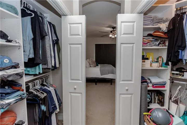 Walk in closet with a ceiling fan