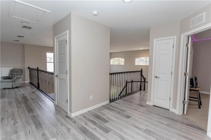 Hallway featuring an upstairs landing and light wood-type flooring