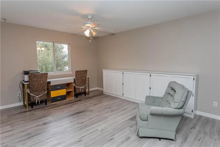 Sitting room with a desk, ceiling fan, and light wood finished floors