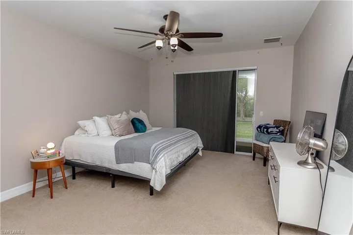 Bedroom with access to outside, light colored carpet, and a ceiling fan