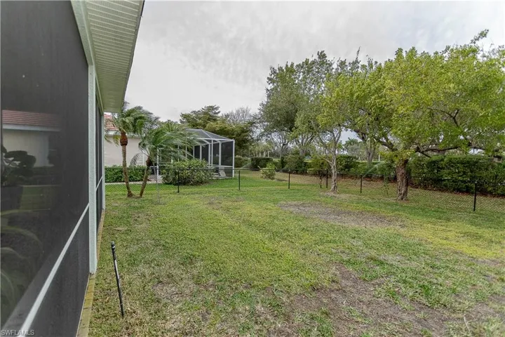 Fenced backyard featuring a sunroom and glass enclosure