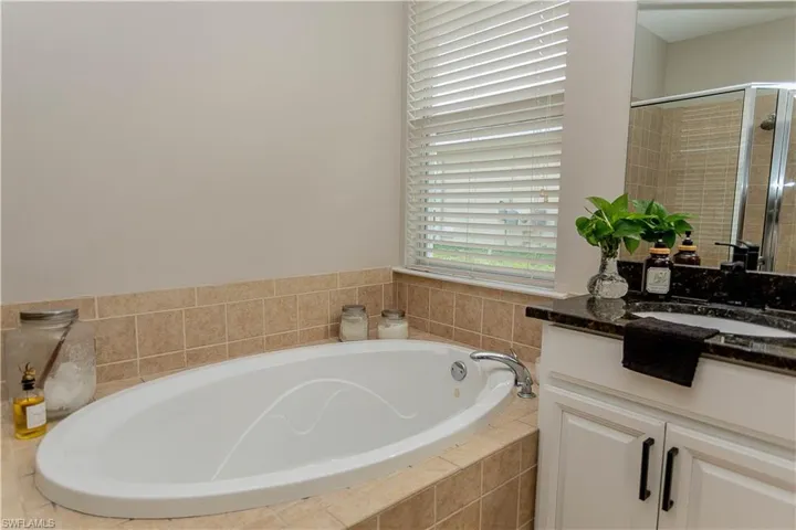 Bathroom with vanity, a bath, and a shower stall
