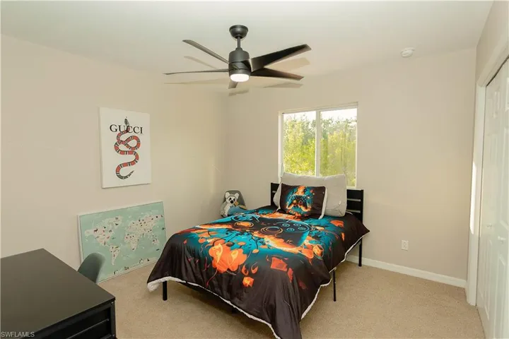 Bedroom with light carpet, a ceiling fan, and a closet