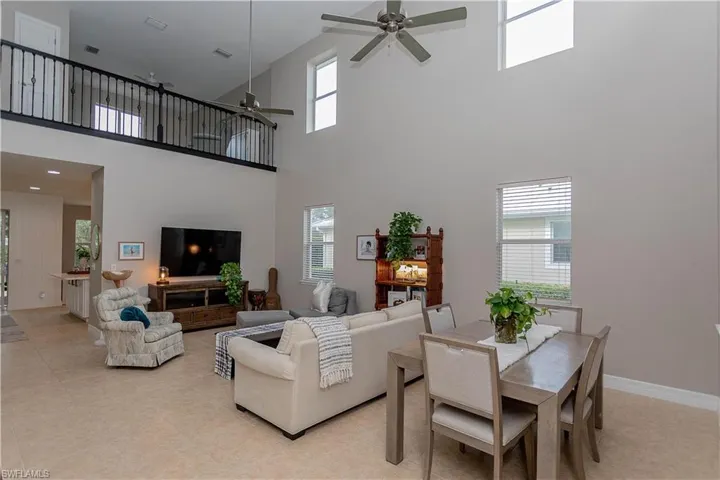 Living area with ceiling fan and a high ceiling
