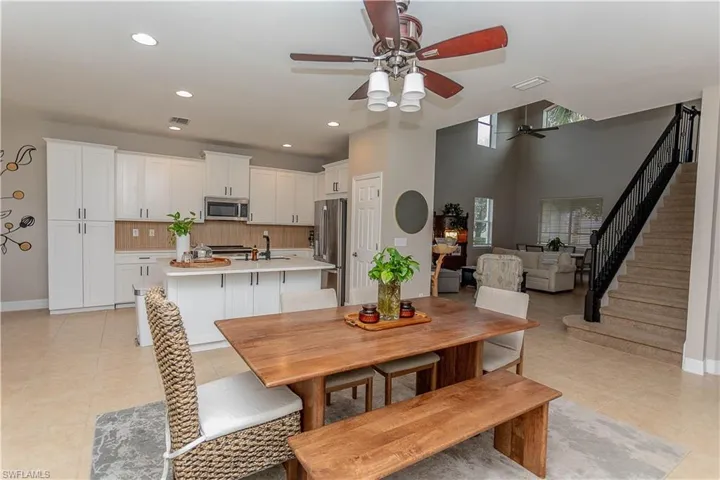 Dining space with a ceiling fan, recessed lighting, a high ceiling, and light tile patterned floors