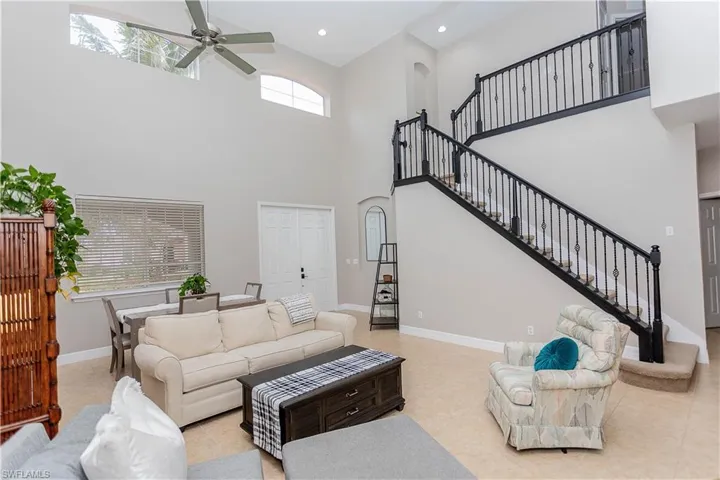 Living room featuring ceiling fan, a high ceiling, and recessed lighting