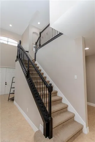 Staircase with recessed lighting and baseboards