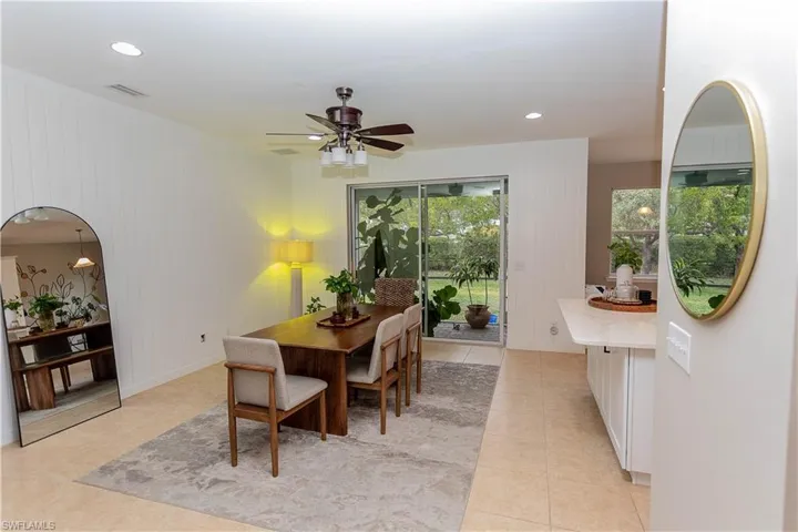 Dining room featuring ceiling fan, recessed lighting, wood walls, and light tile patterned floors