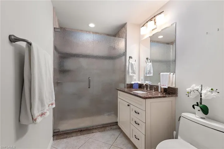 Bedroom featuring a ceiling fan, light tile patterned floors, and baseboards