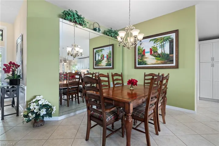 Dining area with baseboards, light tile patterned floors, and an inviting chandelier