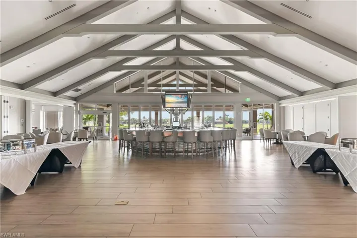 Living area featuring plenty of natural light, vaulted ceiling with beams, wood finished floors, and ceiling fan