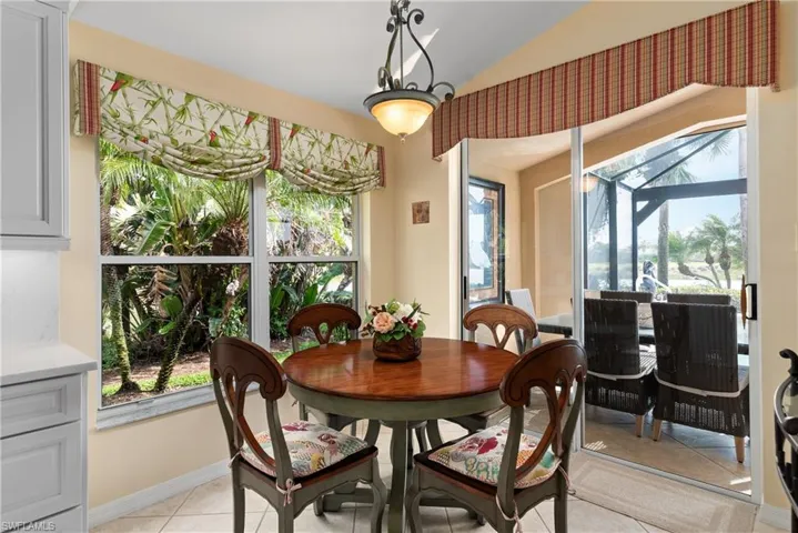 Dining space featuring light tile patterned floors, a sunroom, and baseboards