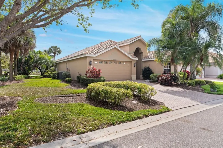 View of front of house featuring a tile roof, driveway, stucco siding, an attached garage, and central AC