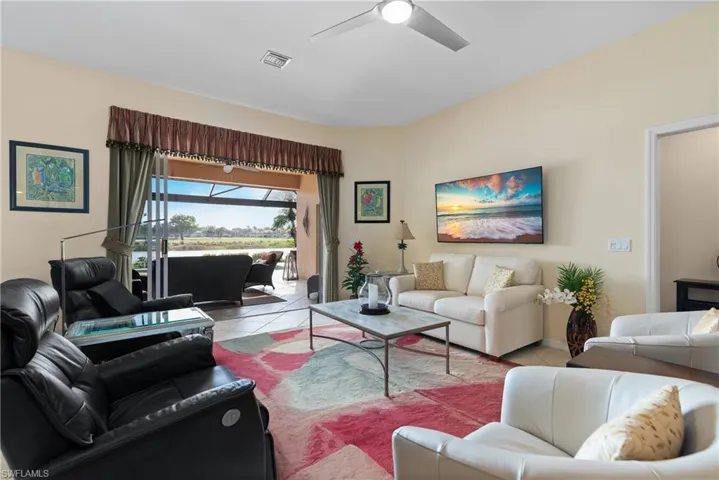 Tiled living room with visible vents and a ceiling fan