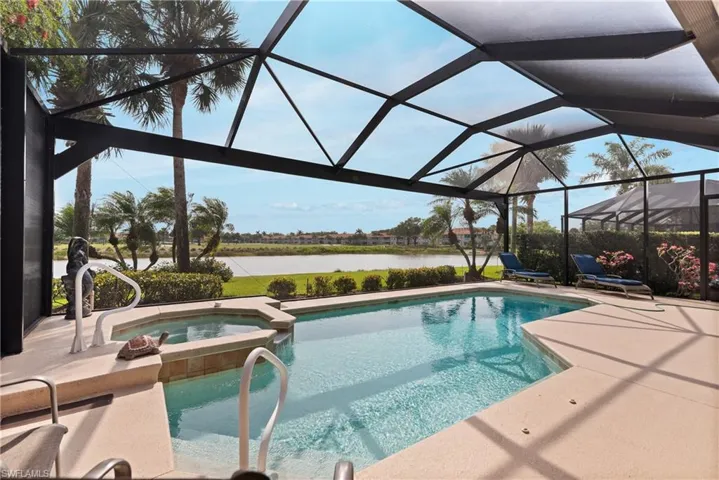 View of swimming pool featuring a pool with connected hot tub, a water view, a lanai, and a patio
