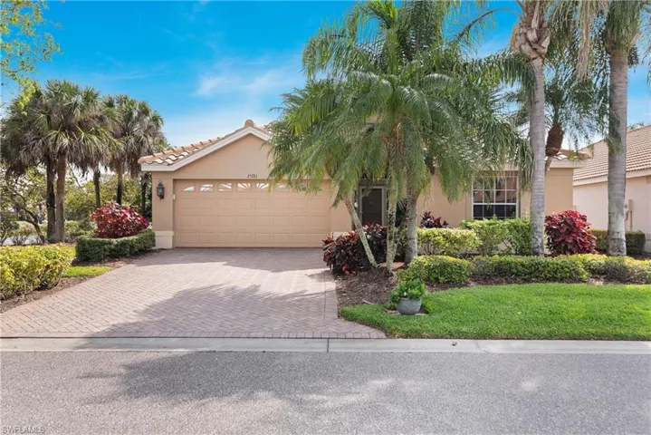 View of front of home featuring a tiled roof, decorative driveway, stucco siding, and an attached garage
