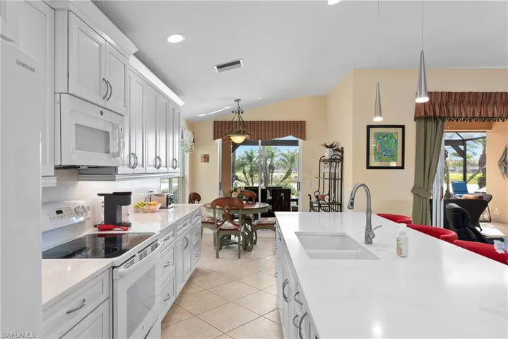 Kitchen featuring visible vents, a sink, a healthy amount of sunlight, and white appliances