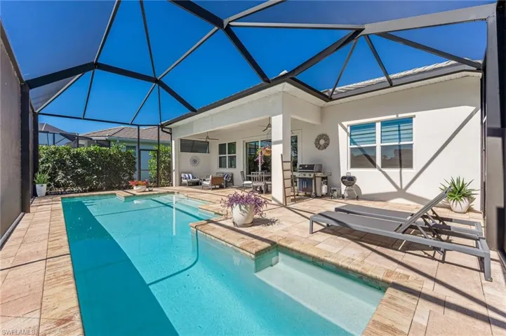 Outdoor pool with glass enclosure, a patio, and ceiling fan
