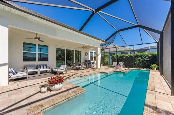 Pool with ceiling fan, an outdoor hangout area, glass enclosure, and a patio