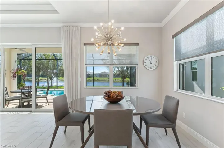 Dining room featuring crown molding, wood finished floors, baseboards, and a chandelier