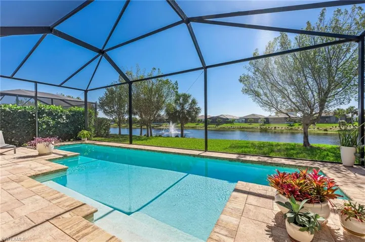 Outdoor pool with a patio, a water view, and a lanai
