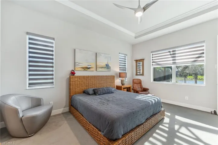 Bedroom with baseboards, carpet floors, a raised ceiling, and ornamental molding